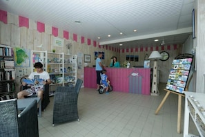A reception area with a counter, a map on the wall, and a bulletin board with photos. - ZEcamping 4 étoiles familial piscine chauffée locatif 28m2 (Saint-Trojan-les-Bains)