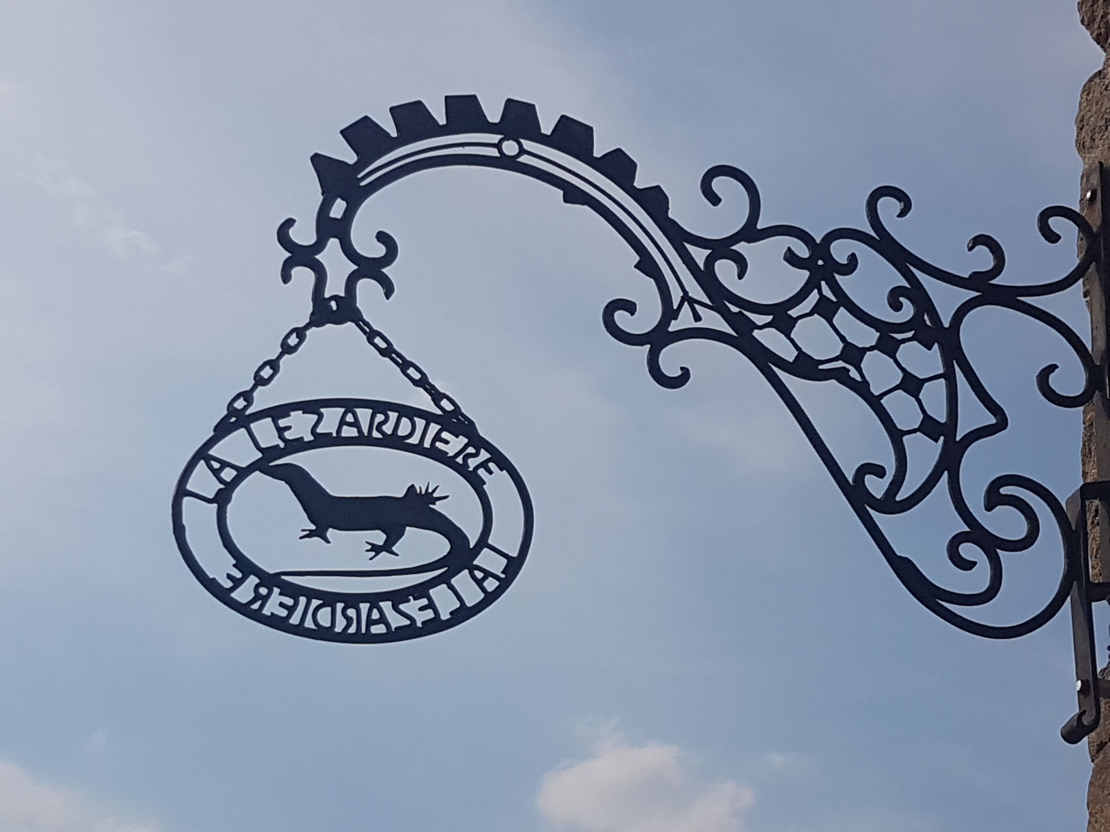 A metal sign with a fox and the text "LARDIERE" against a clear sky.