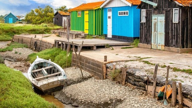 A row of colorful wooden buildings with a dock and a boat. - ZEcamping 4* 4km plage parc aquatique fitness dog friendly club enfant (Saint-Sulpice-de-Royan)
