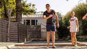 A man and a woman playing with a ball in a backyard with a wooden fence, a house, and trees in the background. - ZEcamping 4* 4km plage parc aquatique fitness dog friendly club enfant (Saint-Sulpice-de-Royan)