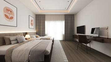 Una habitación de hotel moderna con una cama grande, un escritorio con una computadora portátil y un televisor.
