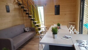 A modern interior with a staircase, a sofa, a dining table with chairs, and a 'To Do' board. - ZEcamping 4* animé piscine couverte locatif TV LV (Caro)