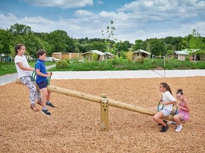 A seesaw in a playground with children playing. - ZEcamping 4* piscine couverte locatif TV LV BBQ 40m2 (Caro)