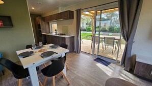 Una cucina moderna con zona pranzo e una porta scorrevole in vetro che dà su un patio esterno.