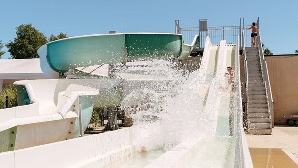 A water slide with a person at the top and another at the bottom.