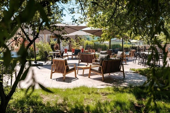An outdoor patio area with wooden furniture and umbrellas.