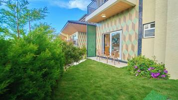 A modern building with a geometric facade, a well-maintained lawn, and outdoor seating.