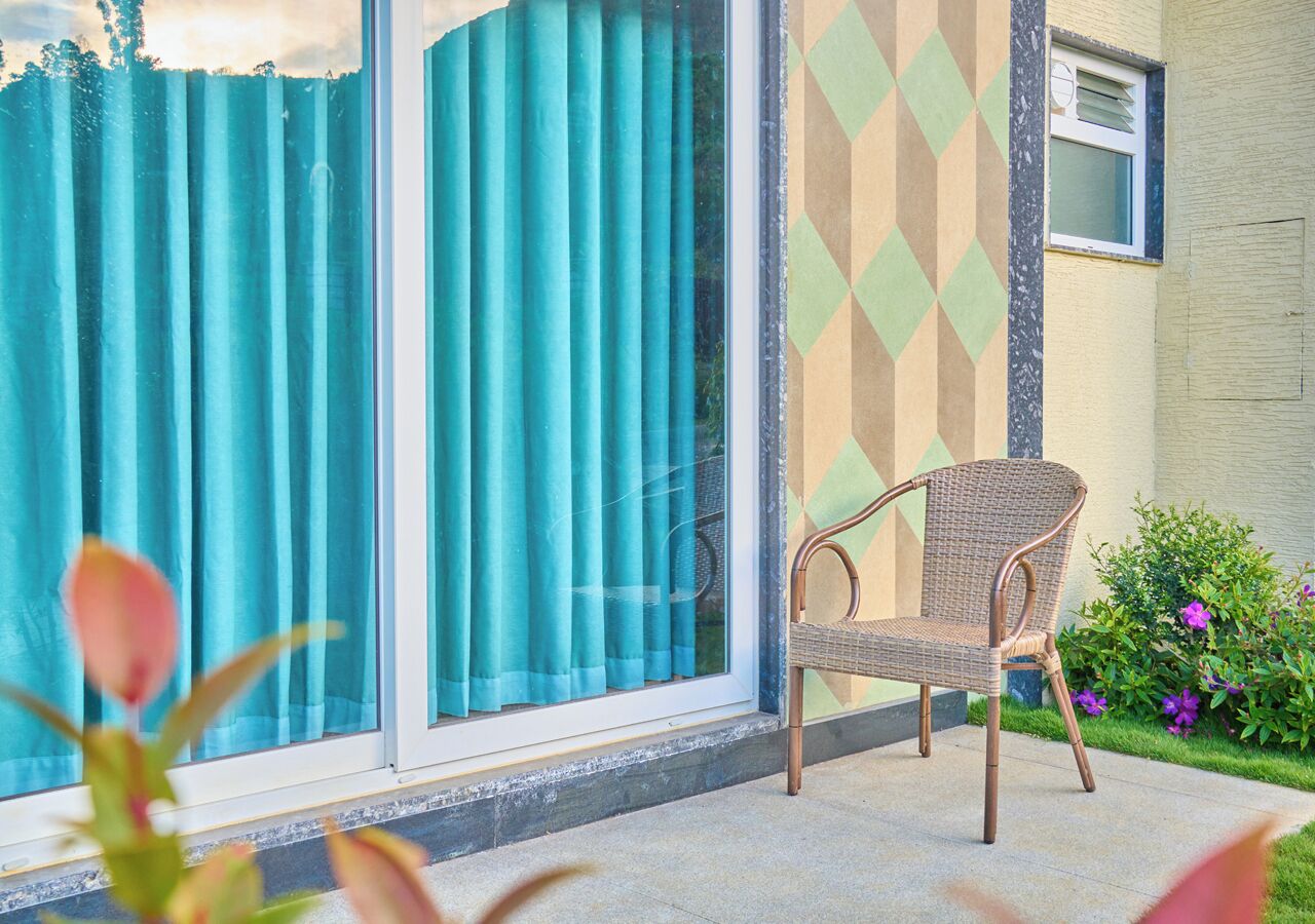 Ein Stuhl vor einem Gebäude mit Fenster und Wand mit Muster.