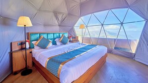 A spacious tent with a large bed, a bedside table, and a lamp. - Cloudskape Resort Ooty by VOYE HOMES (Ooty)