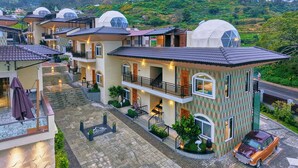 A hotel with multiple dome-shaped structures, a central building with a balcony, and a mountainous backdrop. - Cloudskape Resort Ooty by VOYE HOMES (Ooty)