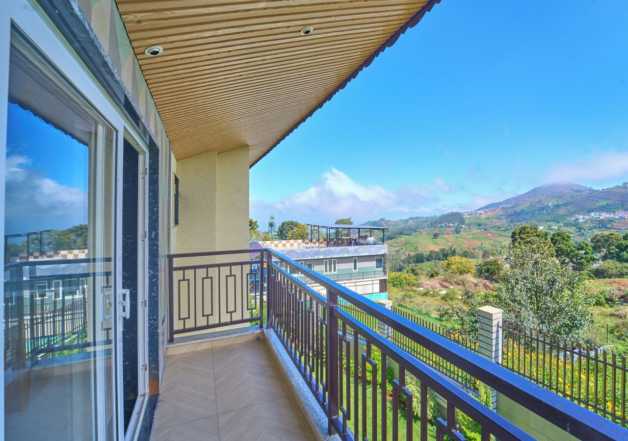A balcony with a view of a hilly landscape.