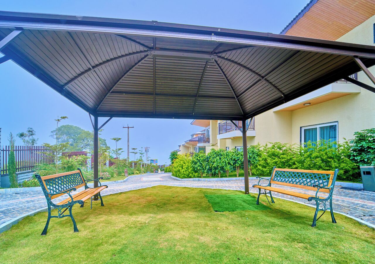 Un espacio de estar al aire libre con techo, con dos bancos de madera.