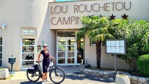A building with a sign reading "LOU ROUCHETOU CAMPING". - ZEcamping 3* pataugeoire piscine dog friendly locatif TV clim 26m2 (Les Assions)