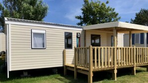 A mobile home with a wooden deck and a covered porch. - ZEcamping 4* 200m plage piscine couverte pet friendly tente TV LV 31m2 (Plomodiern)