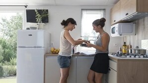 A compact kitchen with a refrigerator, microwave, and gas stove. - ZEcamping 4* 200m plage piscine couverte pet friendly tente TV LV 31m2 (Plomodiern)