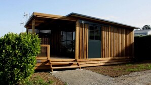 A single-story wooden building with a covered porch and a small entrance. - ZEcamping 4 étoiles familial 200m plage piscine couverte tente TV LV (Plomodiern)