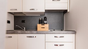 A modern kitchen with white cabinets, a grey countertop, and a built-in stove. - Garibaldi - Modern 1 BR in Brera by Rentopolis (Milan)