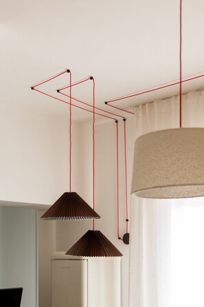 A room with a modern pendant light fixture and a cylindrical shade hanging from the ceiling. - Garibaldi - Bright Cozy 1 BR in the Heart of Brera (Milan)