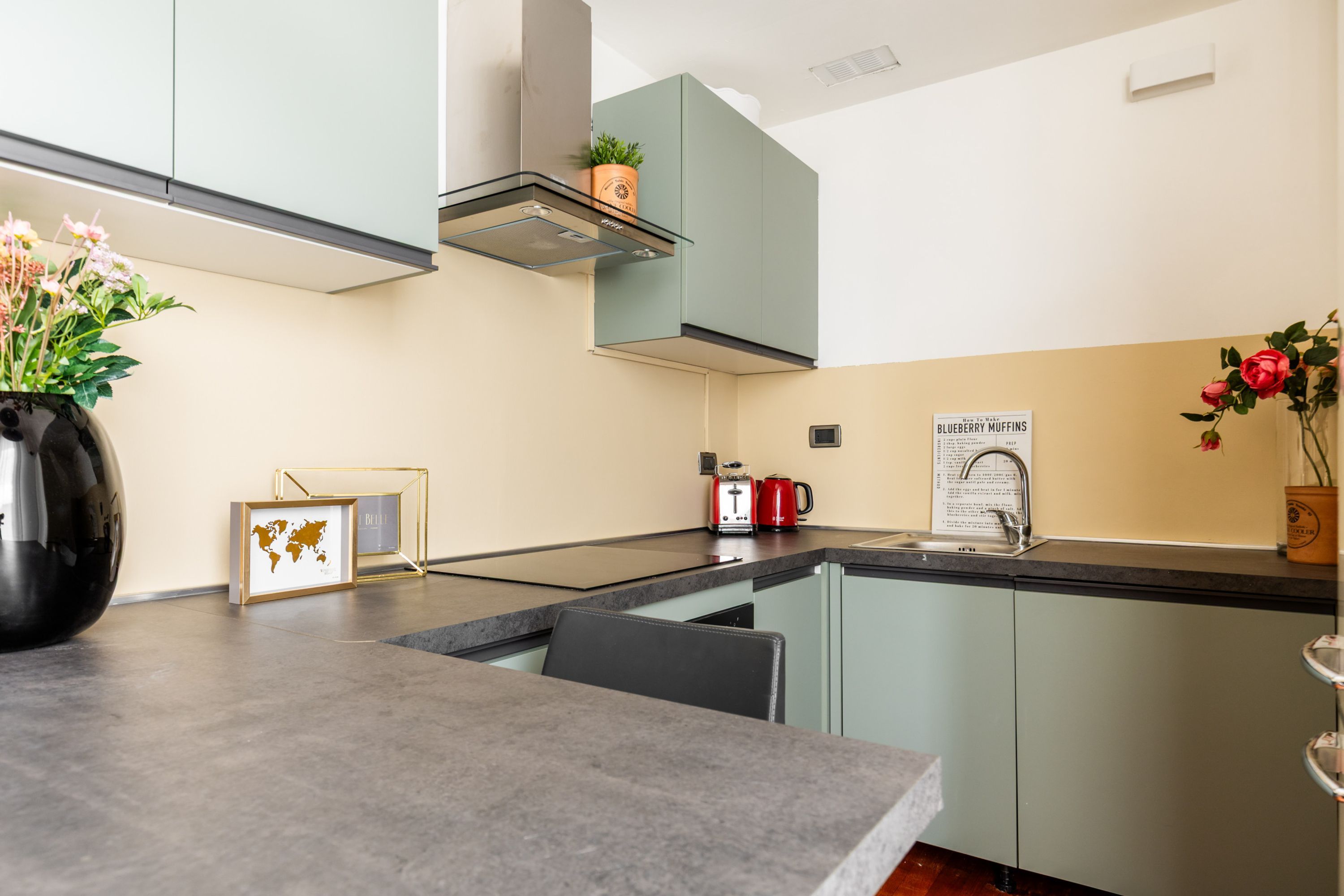 A modern kitchen with a central island, a built-in oven, and a range hood.
