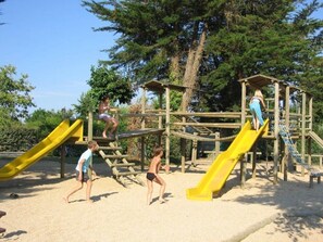 Une aire de jeux dotée de plusieurs toboggans et d’installations d’escalade.
