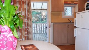 Eine kleine Küche mit Holzschränken, einer eingebauten Mikrowelle und einem Fenster über der Spüle.