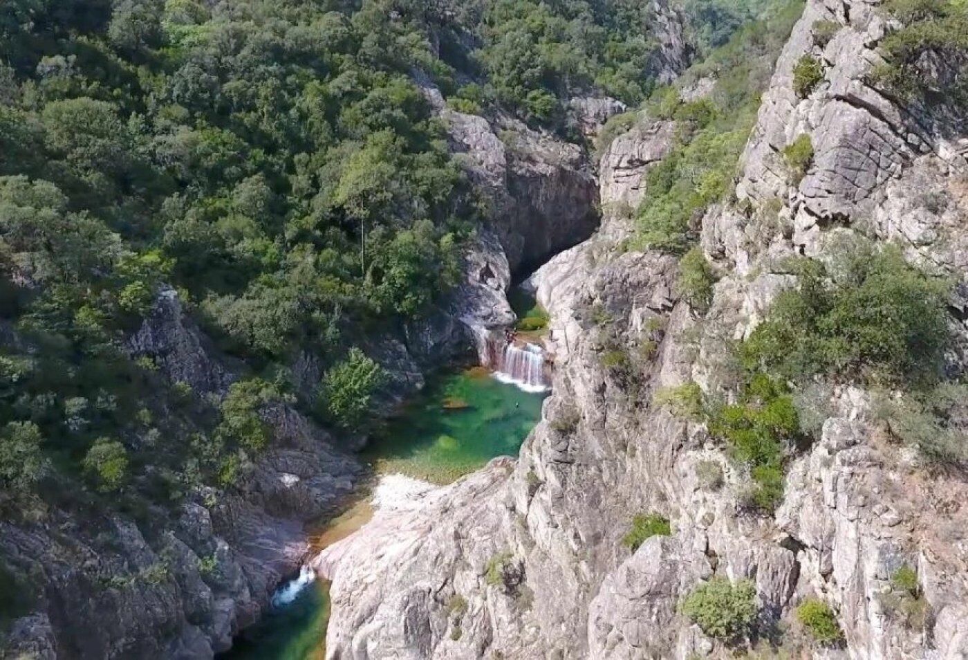 Ein tiefes Canyons mit einem Wasserfall und einem Fluss.