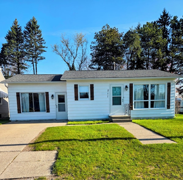 A single-story house with a front porch, a garage, and a well-maintained lawn.