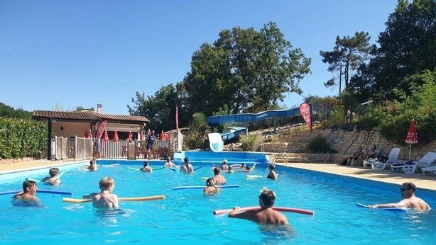 Une piscine où des personnes utilisent des bouées ou d’autres dispositifs de flottaison.