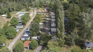 An aerial view of a residential area with multiple houses, a swimming pool, and a tall tree. - ZEcamping 3*chiens acceptés piscine en bord de rivière avec Canoë (Mazères)