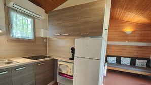 Una cocina compacta con microondas, refrigerador y lavamanos.