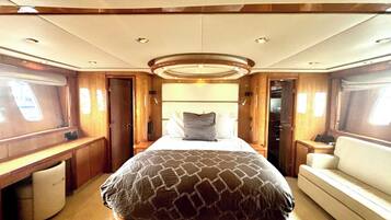 A spacious interior with a large bed, a desk, and a seating area.