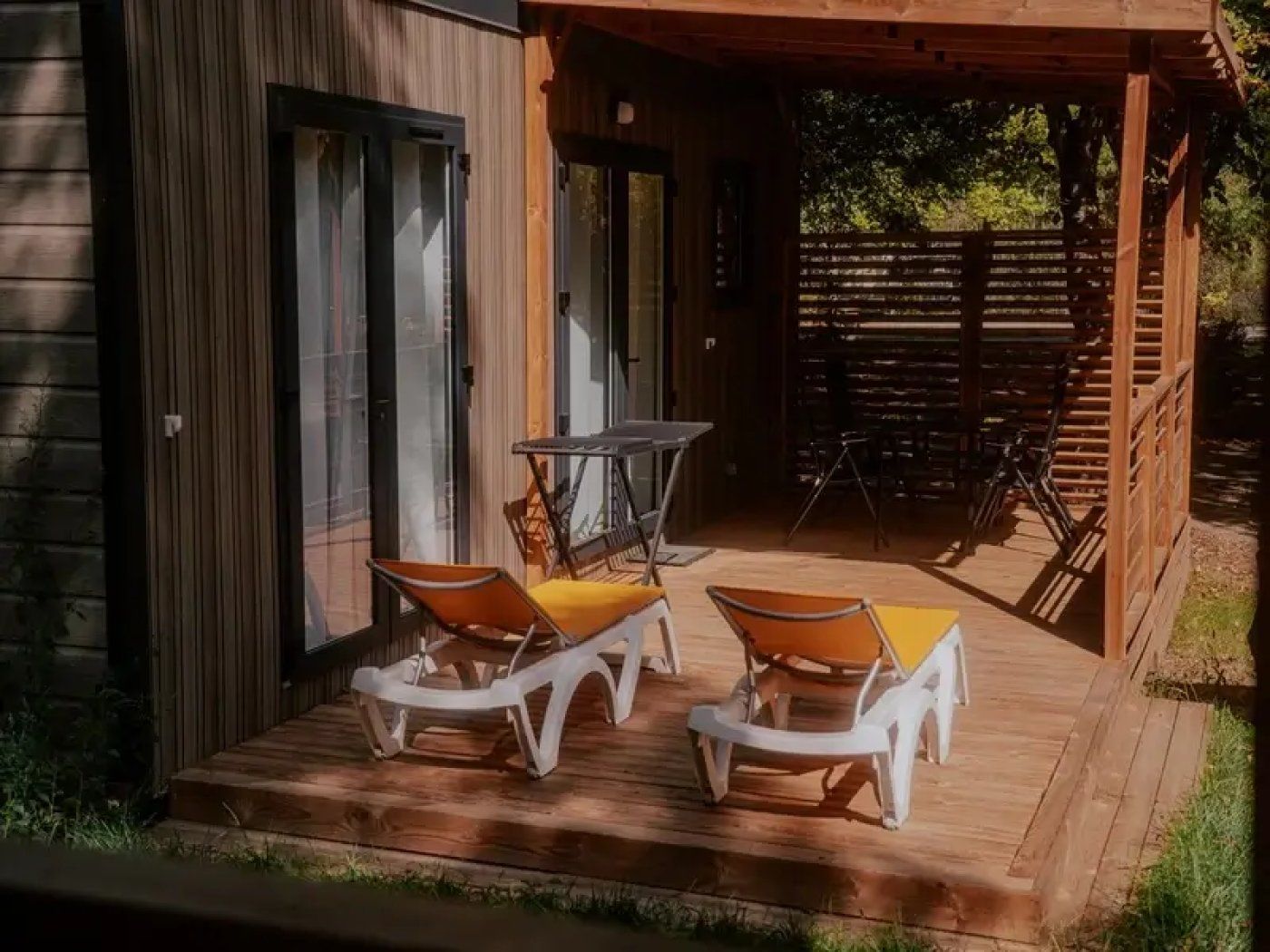 A wooden deck with outdoor seating and a covered area.