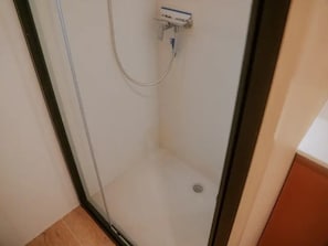 A glass-enclosed shower area with a white tiled floor and a visible drain. - ZEcamping 3* piscine chauffée dog friendly animations locatif clim (Florac)