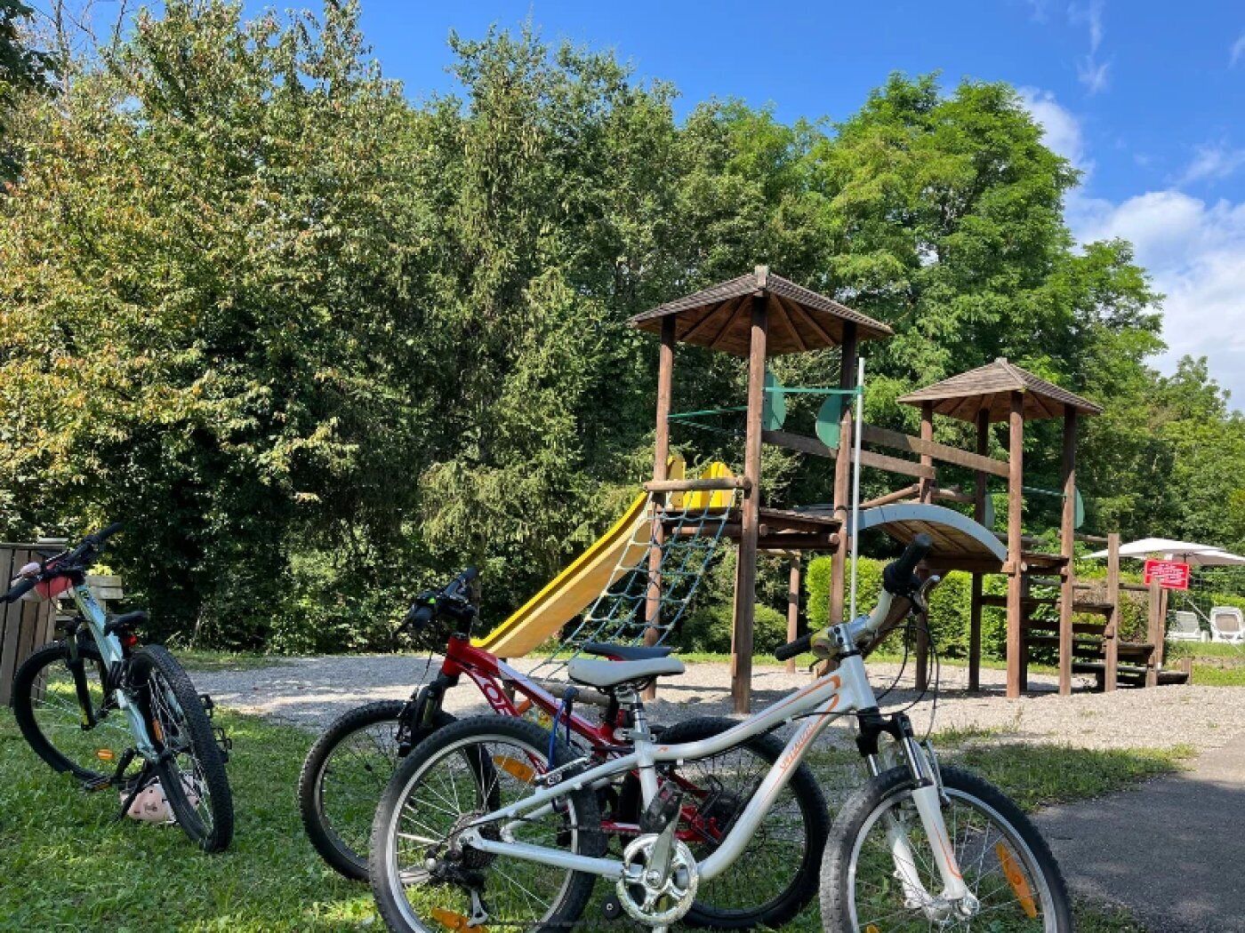 Un parque infantil con una estructura de madera para escalar y un tobogán.