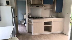 Kompakti keittiö, jossa on mikroaaltouuni, liesi ja pesuallas.