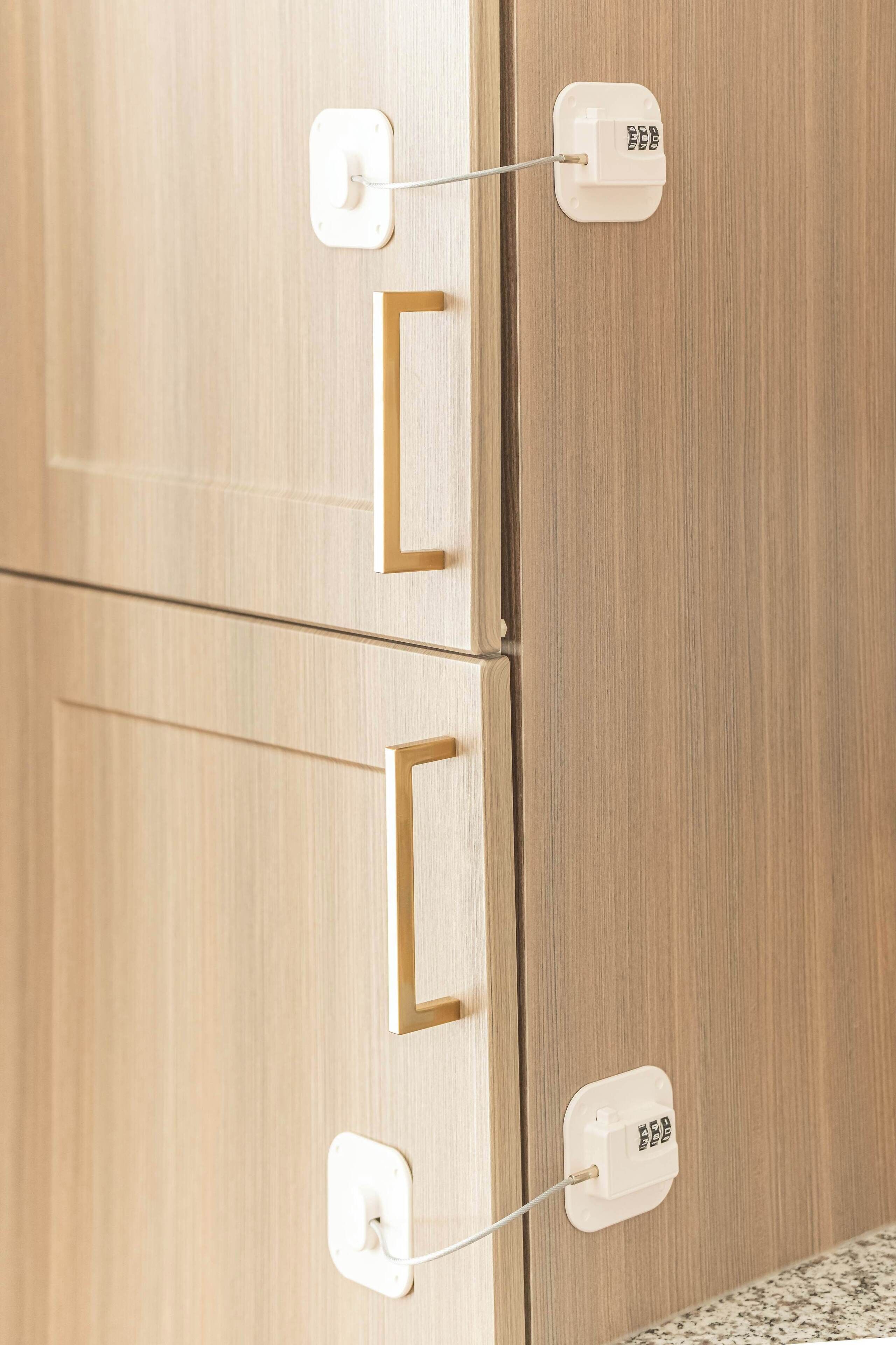 A wooden door with two white electrical outlets and a gold-colored handle.
