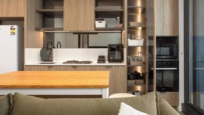 Eine moderne Küche mit integrierten Geräten, Holzschränken und einem Essbereich mit einem Holztisch.