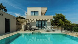 A modern villa with a swimming pool, stone walls, and a two-story structure. - Villa Morska vila with pool and spectacular views in a small fishing village. (Vinišće)