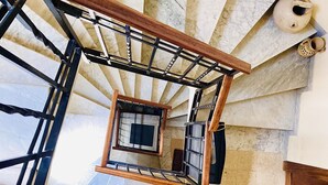 Un escalier en colimaçon avec des marches en marbre et une rampe en bois.