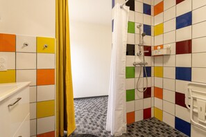 A bathroom with a shower, a toilet, and a sink.