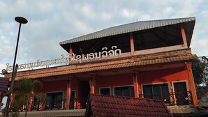 A building with a red facade, a covered upper section, and a sign with text. - Houayxai Riverside Phonevichith Hotel (Houayxay)