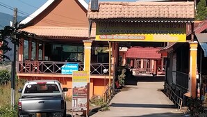 A hotel with a traditional architectural style, featuring a prominent entrance with a tiled roof and a balcony. - Houayxai Riverside Phonevichith Hotel (Houayxay)