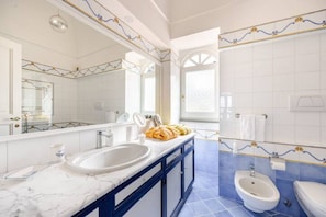 A bathroom with a marble sink, a bidet, and a large mirror. - Villa Coralia - Private Garden&Sea View in Capri (Capri)