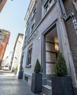 A building with a sign that reads "LEICESTER HOTEL". There are two potted plants in front of the entrance. - Hotel Kernhof Self Check-in (Zürich)
