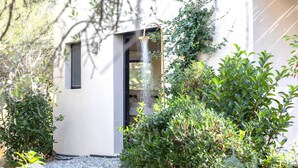 A modern building with a minimalist design, featuring a small entrance and a visible shower area. - Contemporary sea-view villa with large infinity pool and walking distance to the beach (Zonza)