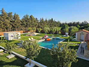 A backyard with a swimming pool, lounge chairs, a gazebo, and a small brick building. - Villa Nectaris-bizerte (Menzel Jemil)