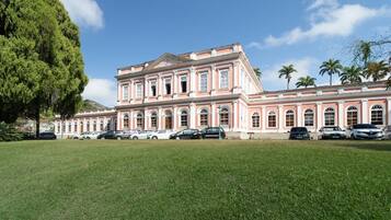Um edifício grande e rosa com várias janelas e uma entrada central.
