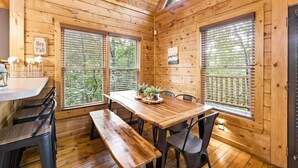 A wooden cabin with a dining table, benches, and chairs. - Little Woods Cabin | Family-Friendly w/ Games! (Sevierville)