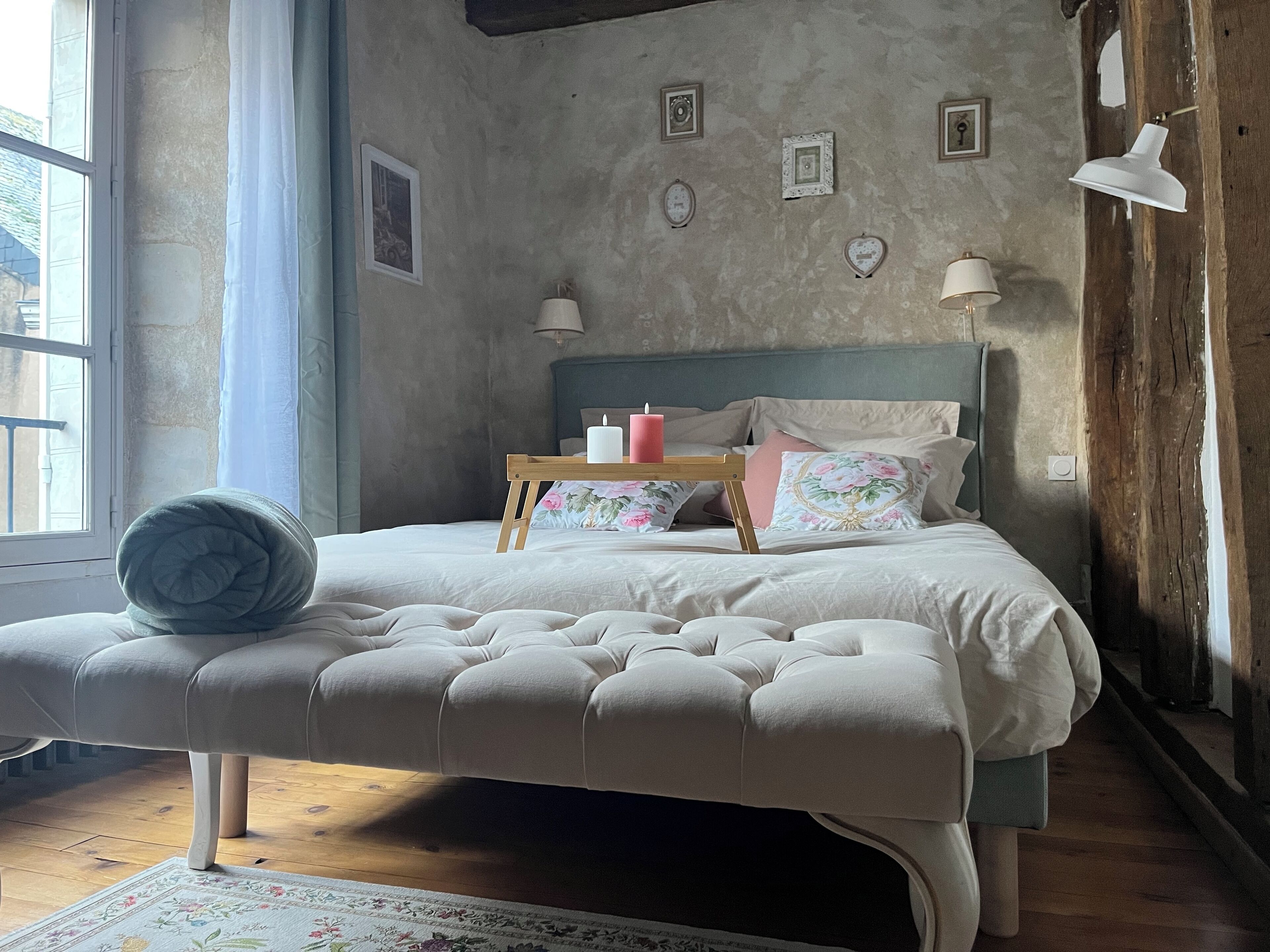 A bedroom with a bed, bedside tables, and a window.