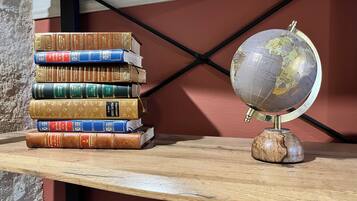Un estante de madera con una pila de libros y un globo terráqueo.